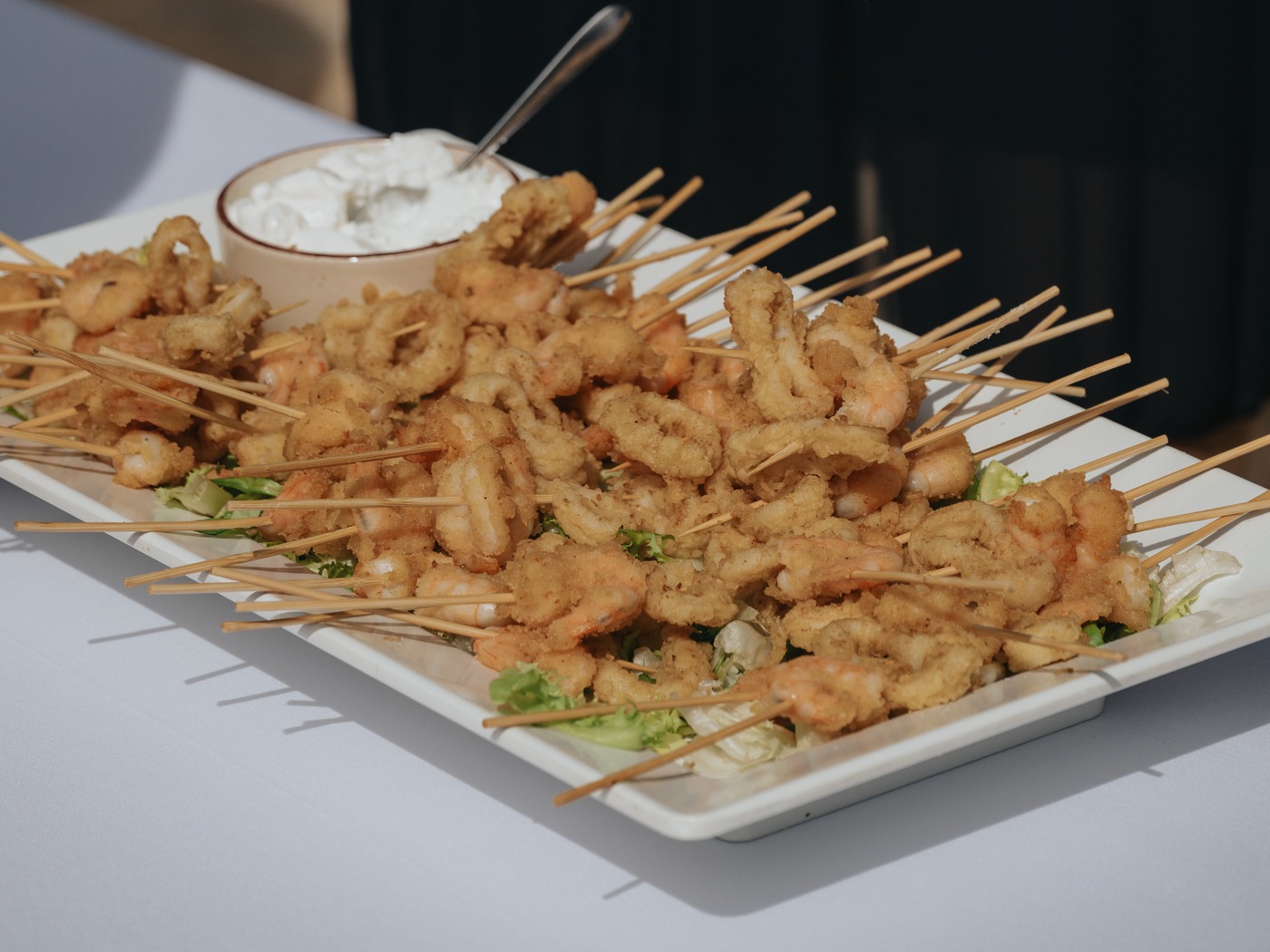 Brochetas de gambas y calamares fritos servidas en una bandeja
