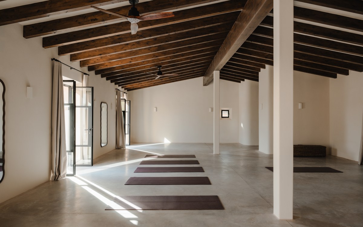 El Estudio de TERRA con esterillas de yoga en el suelo, bajo las vigas de madera